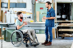 Rollstuhlfahrer unterhält sich im Bereich Werkstatt-Transfer.
