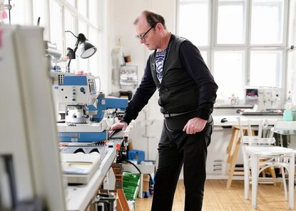 Älterer Mann arbeitet in einer Werkstatt.