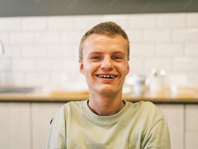 Junge lächelt glücklich in die Kamera.